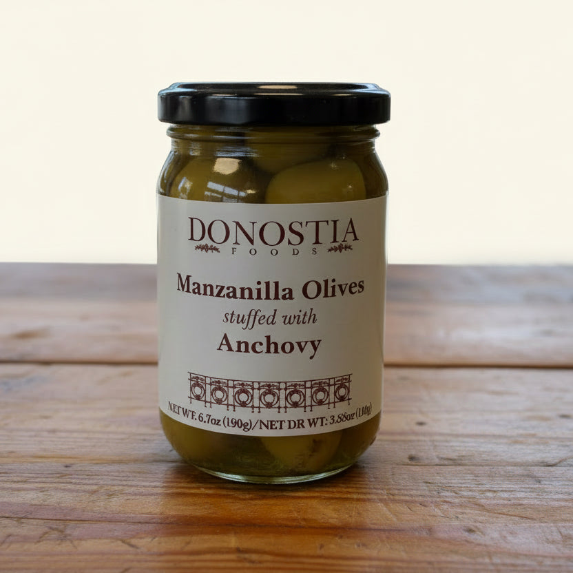 Jar of Donostia Manzanilla Olives stuffed with Anchovy on a wooden surface